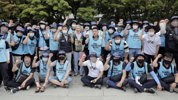 김진숙 금속노조 한진중공업지회 조합원(민주노총 부산본부 지도위원)(가운데)이 7월 28일 오후 서울 여의도 산업은행 앞에서 연 ‘현장으로 돌아가자. 김진숙 복직 응원 기자회견’을 마친 뒤 노조 대우버스지회 조합원들과 함께 사진 촬영을 하고 있다. ⓒ 변백선 기자