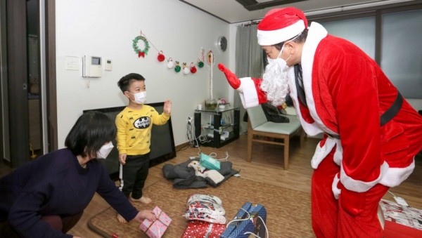 1. 산타클로스로 변신한 백군기 용인시장이 24일 크리스마스 이브를 맞아 최정민(10· 가명)군의 집에 깜짝 방문, 선물을 전달하기에 앞서 최군과 반갑게 인사하고 있다. (1).jpg